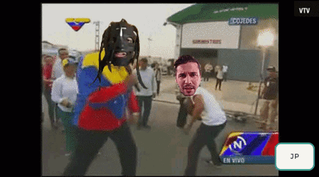 a tv screen shows a man in a mask dancing in front of a building that says cojedes