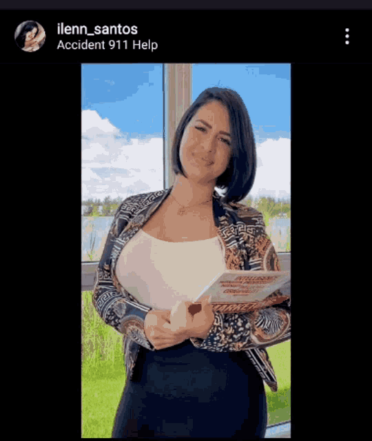a woman in a white tank top and a leopard print jacket is holding a book in front of a window ..