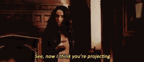a woman is standing in a dark room and talking to someone .