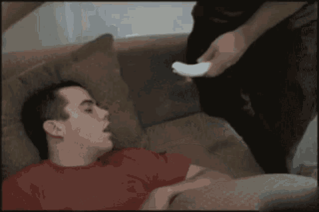 a man laying on a couch with his mouth open