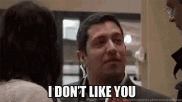 a man in a suit is talking to a woman and saying `` i don t like you '' .