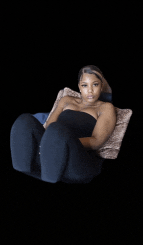 a woman in a black strapless top is laying on a couch
