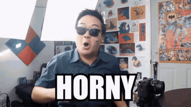 a man wearing sunglasses says horny while standing in front of a camera