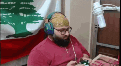 a man with a beard and headphones is playing a video game .