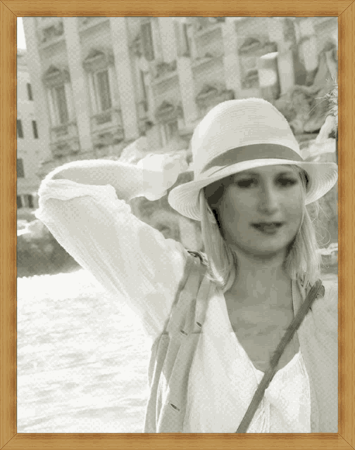 a woman wearing a white hat is standing in front of a body of water