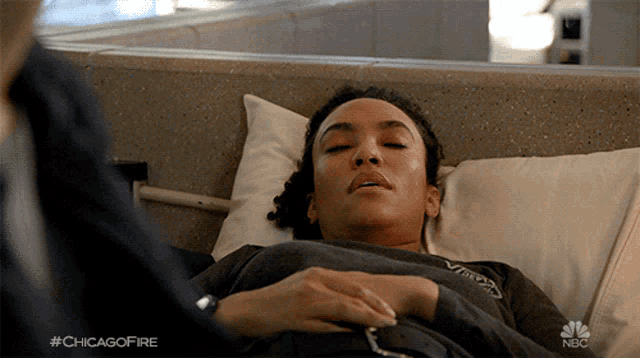 a woman laying in a hospital bed with #chicagofire written on the bottom right