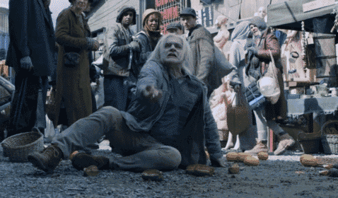 a group of people are gathered around a man on the ground