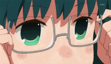 a girl with green eyes is wearing glasses and looking at something