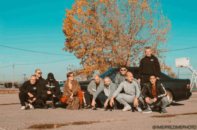 a group of people posing in front of a car with the watermark imeipre zimephoto