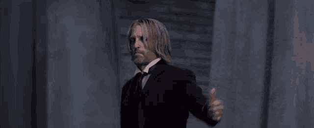 a man in a suit giving a thumbs up