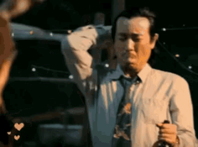 a man in a suit and tie is holding a bottle of wine in his hand .
