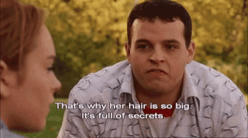 a man and a woman are talking to each other and the man is talking about her hair being big .