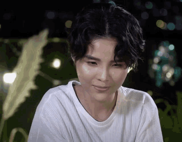 a woman wearing a white shirt looks down at something