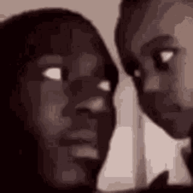 a close up of two people 's faces looking at each other with their eyes closed .