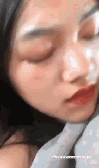 a close up of a woman 's face with her eyes closed and her mouth open .