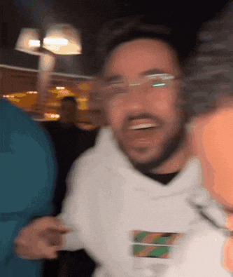a blurry picture of a man wearing glasses and a white shirt