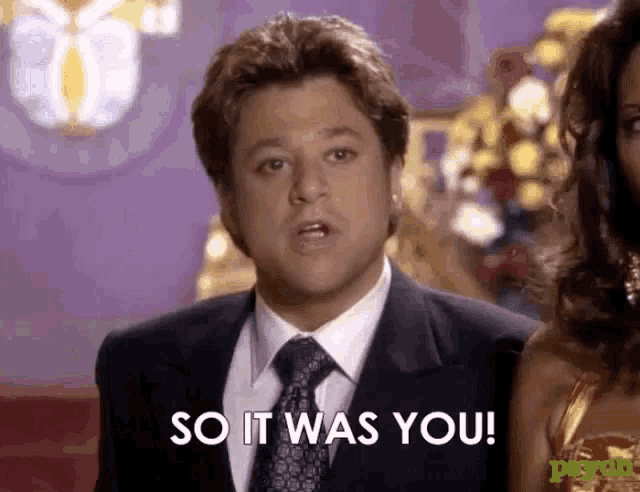 a man in a suit and tie is standing next to a woman and says so it was you .