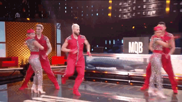 a group of people are dancing in front of a sign that says mob on it