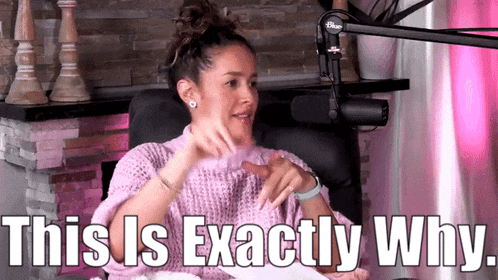 a woman in a pink sweater is sitting in front of a microphone and says `` this is exactly why . ''