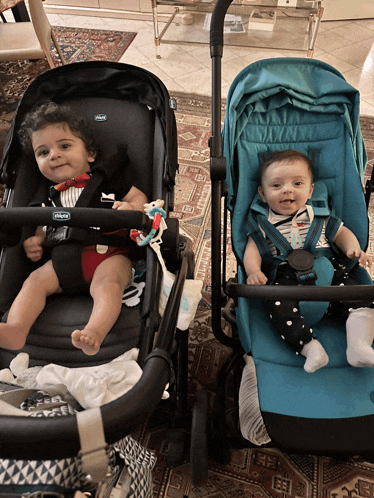 two babies are sitting in a chicco stroller next to each other