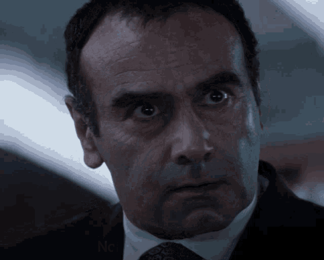 a man in a suit and tie is looking up at the camera