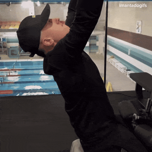 a man wearing a baseball cap is doing exercises in front of a pool with the hashtag imantadogifs