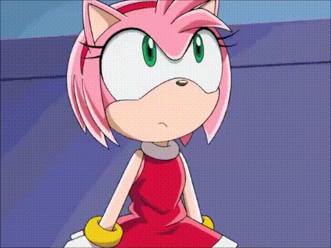 amy rose from sonic the hedgehog is sitting down and looking at the camera with an angry look on her face .