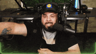 a man wearing headphones and a lidl hat talks into a microphone