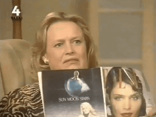 a woman sits in a chair holding two magazines one of which is titled sun moon stars