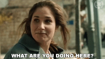 a woman is asking what are you doing here while eating a sandwich .