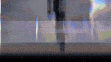 a blurred image of a person standing in front of a glass wall