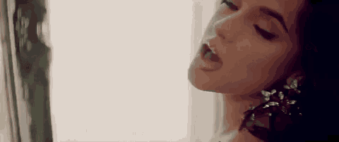 a close up of a woman 's face with her mouth open and her tongue sticking out .