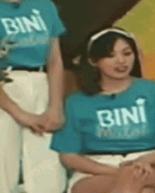 a woman in a blue shirt that says bini on it