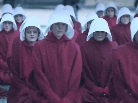 a group of women in red robes and white hats