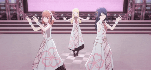 three anime girls are standing on a stage with their hands in the air