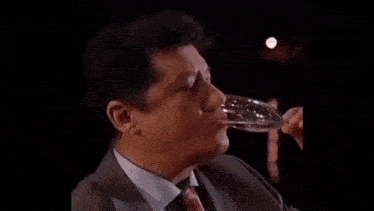 a man in a suit and tie is smoking a cigarette with a lighter .