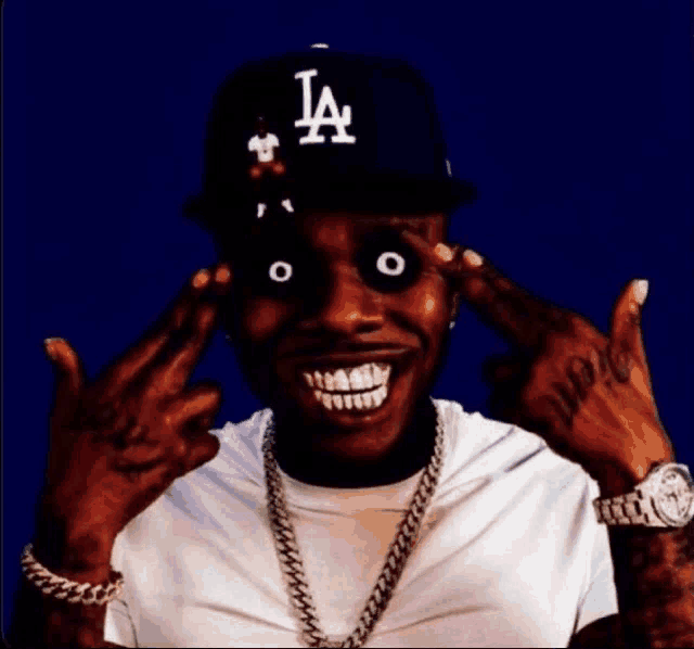 a man wearing a la hat and a white shirt