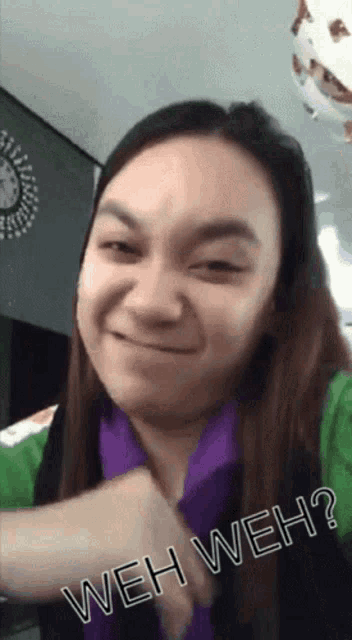 a woman in a green shirt is making a funny face and says weh weh ?