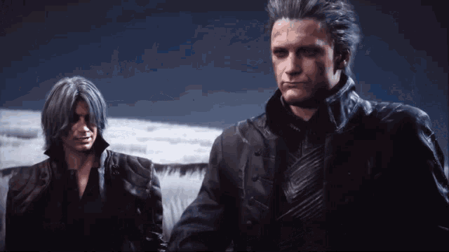 two men are standing next to each other in a dark room with a cloudy sky in the background