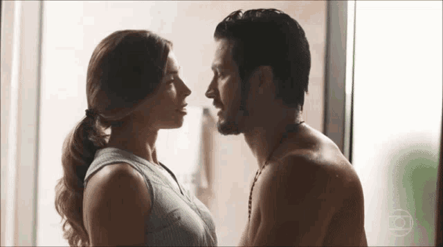 a man and a woman are looking at each other and kissing .
