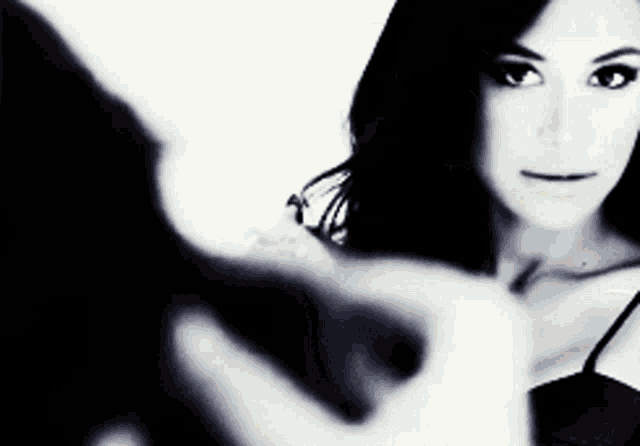 a black and white photo of a woman looking at herself in a mirror