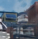 a blurry picture of a car driving down a street with a brick building in the background .