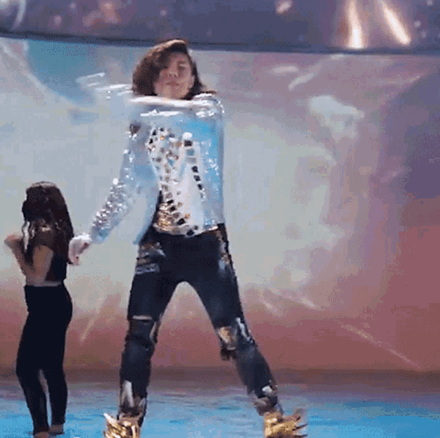 a man in a blue jacket is dancing with a girl