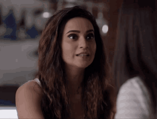 a woman with long hair looks at another woman