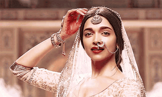 a woman with a nose ring is wearing a white veil