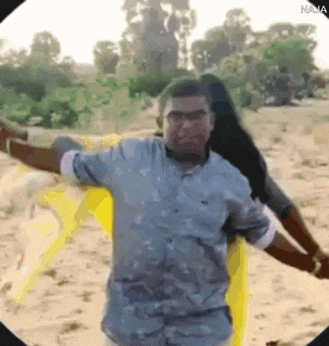 a man is standing next to a woman with his arms outstretched