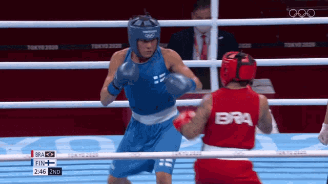 two boxers are fighting in a ring and one of them has bra on the back of his shirt