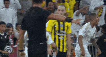 a man in a yellow and black striped shirt with the word saudi on the front