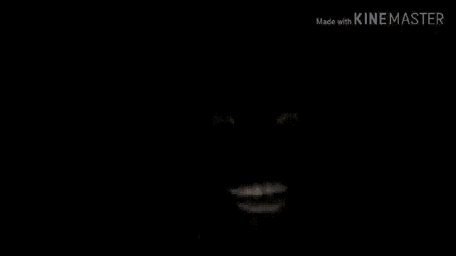 a close up of a person 's face in a dark room in a video made with kinemaster .