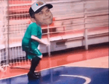a man in a hat is standing on a basketball court with his head on the floor .